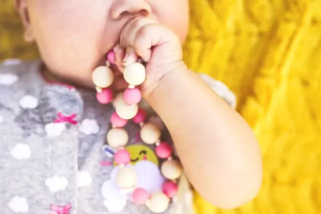 Baby nuckelt an Kette