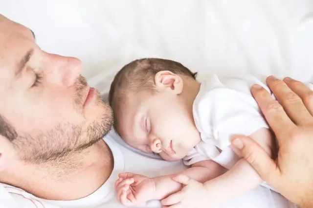Vater und Kind schlafen im Bett