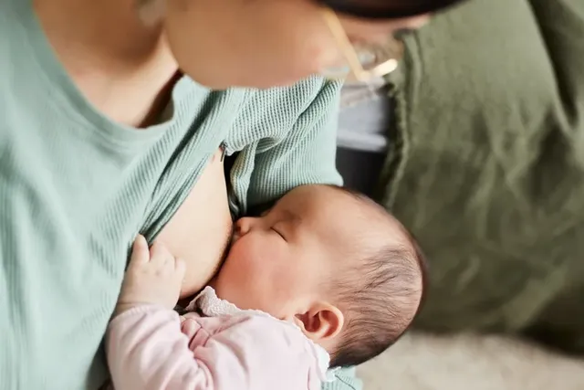 Junge Mutter und ihr Baby mit voller Milchflasche