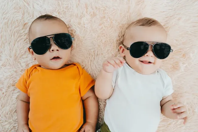 Babys liegen mit coolen Sonnenbrillen im Bett