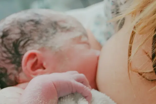 Junge Mutter stillt ihr Baby direkt nach der Geburt