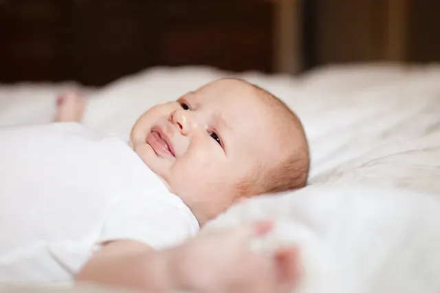 Baby liegt im Bett und schreit