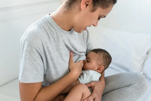 Junge Mutter stillt ihr Baby