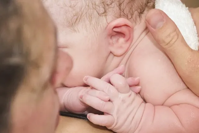 Junge Mutter hält Baby auf der Brust