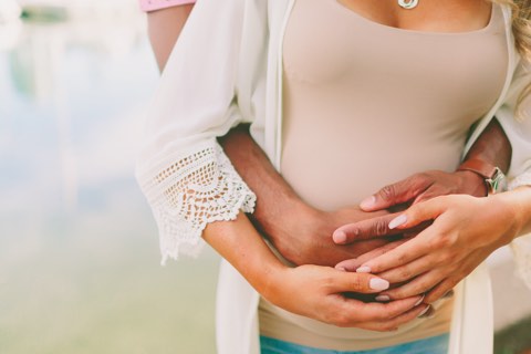 Mann hält den Bauch seiner schwangeren Frau