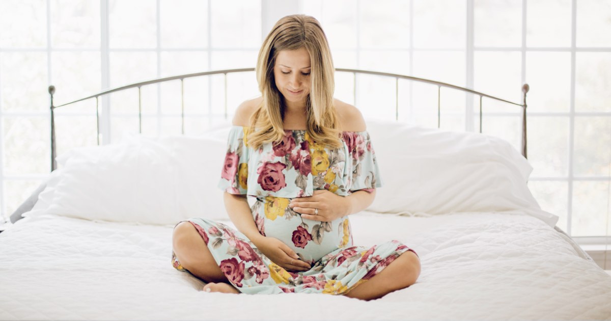 Schwangere Frau im Bett hält Babybauch