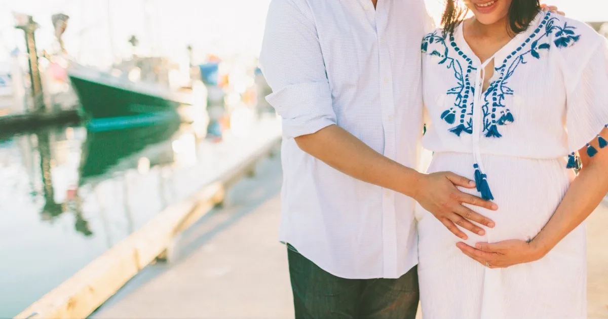 Schwangeres Paar auf Urlaub hält Babybauch