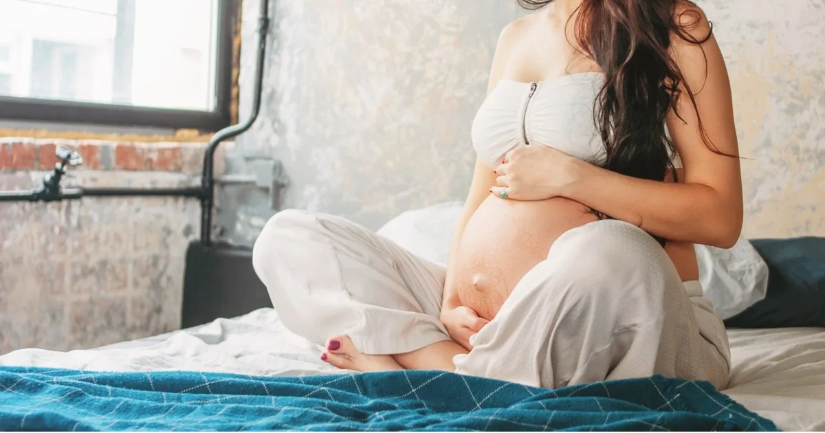 Schwangere Frau hält sich ihren Babybauch