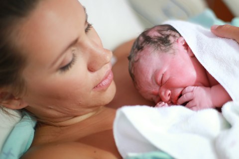 Mutter nach Geburt mit neugeborenem Baby