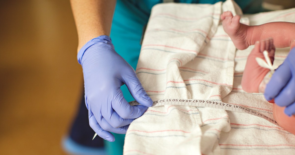 Neugeborenes wird im Krankenhaus von Krankenschwester vermessen