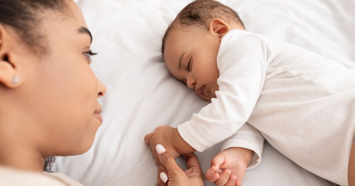 Aufgewachtes Baby liegt im Bett