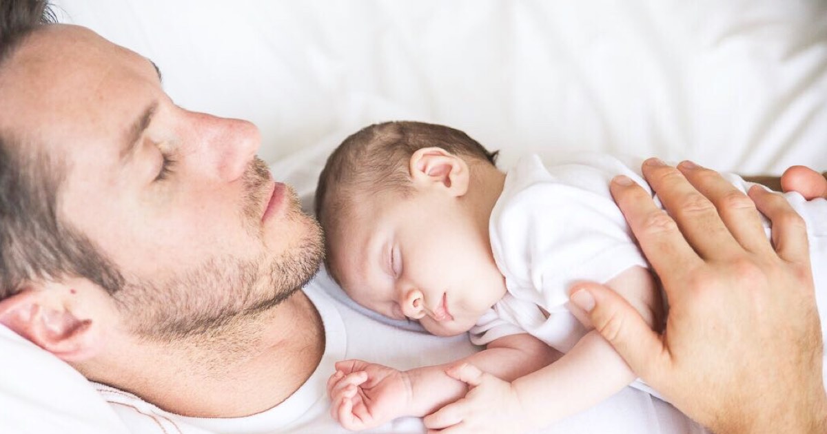 Vater und Kind schlafen im Bett