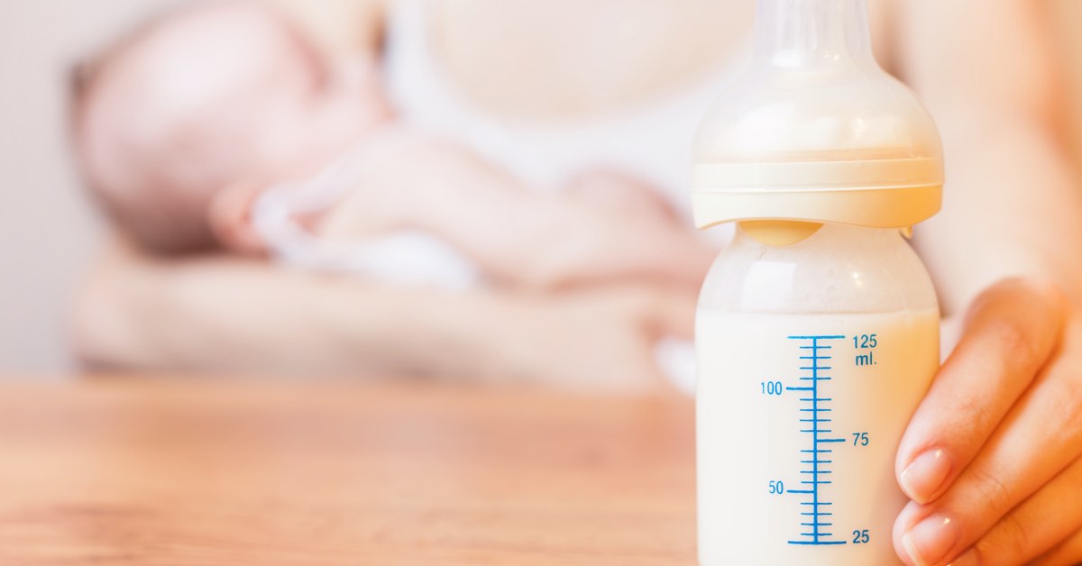 Junge Mutter und ihr Baby mit voller Milchflasche