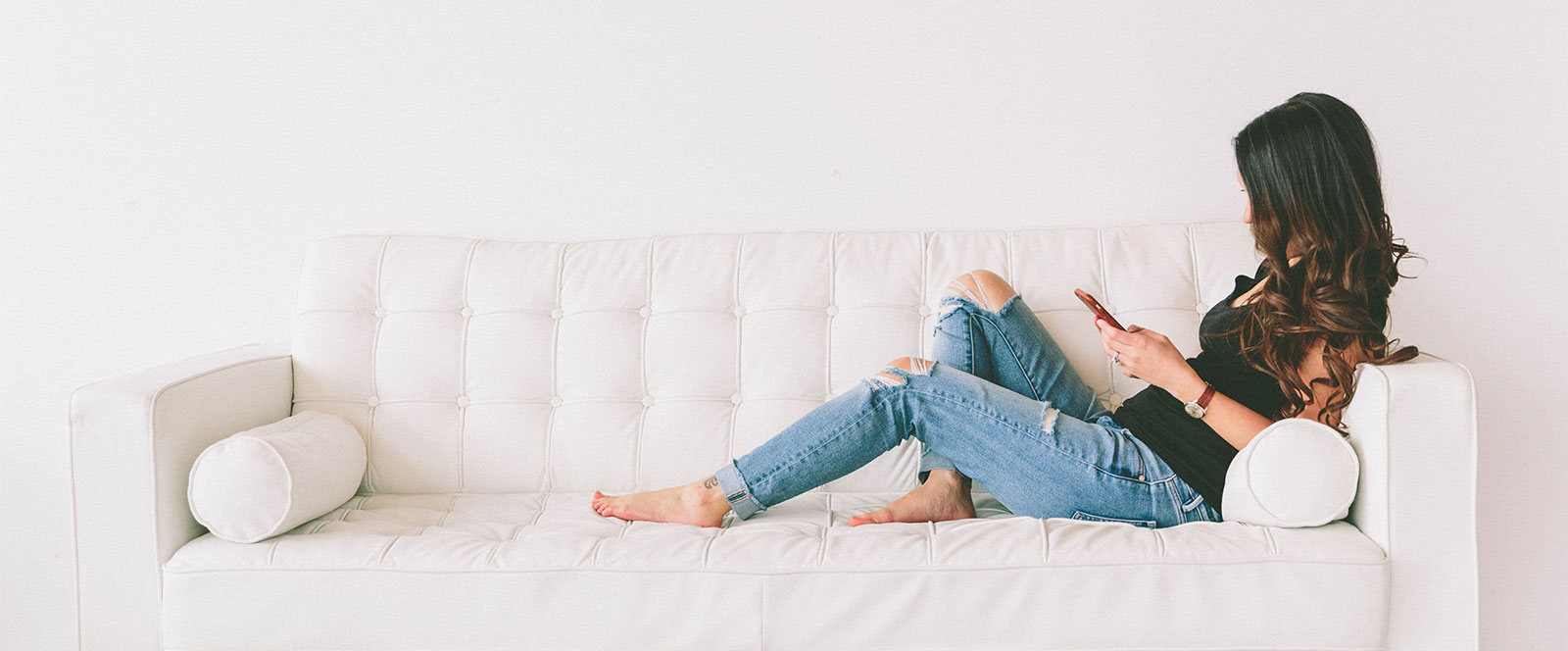 Kategorienbild einer Frau die auf einem Sofa ihr Smartphone benutzt