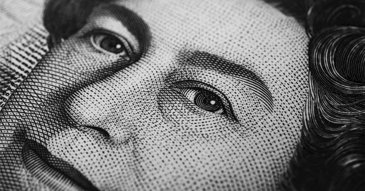 Makroaufnahme eines gezeichneten Gesichts auf einer Banknote.