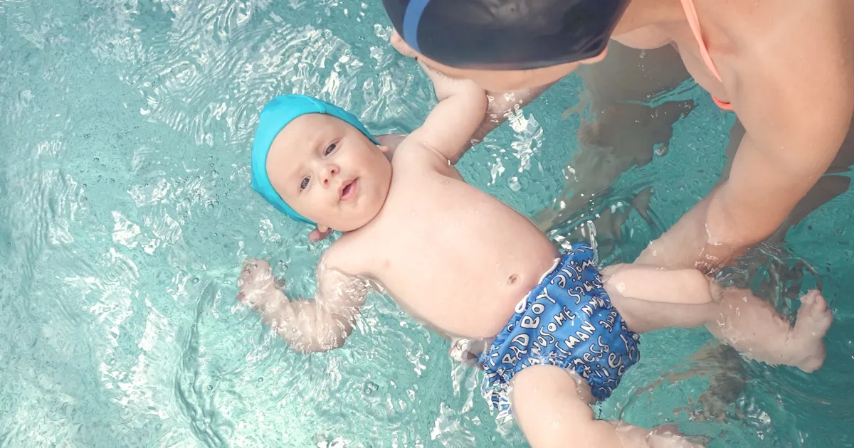 Baby lernt Schwimmen mit Elternunterstützung im Pool