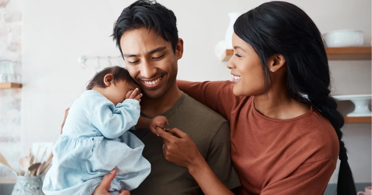 Junge Familie mit Baby zu Hause, liebevolles Zusammensein