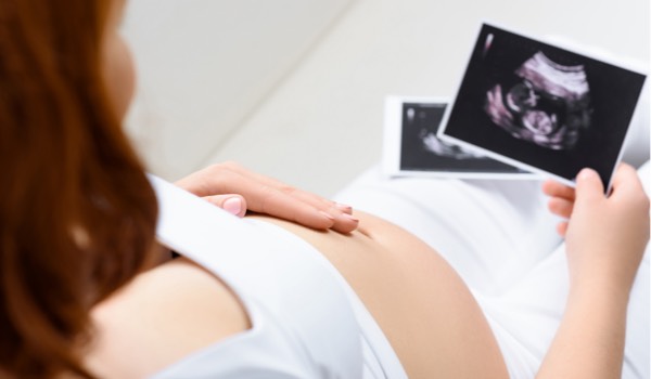 Schwangere Frau mit Ultraschall ihres Babys