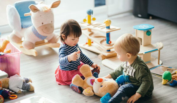 Zwei Kleinkinder spielen gemeinsam in einem Café