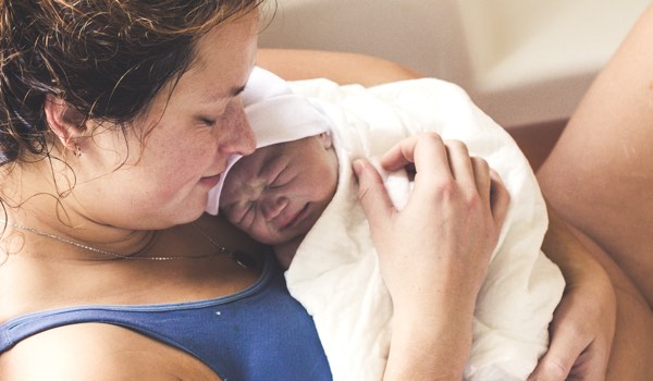 Frischgebackene Mutter mit Baby in Geburtshaus